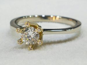 Kombinovaný prsten se středovým briliantem o velikosti 3,85 mm, 6 briliantů o velikosti 1,05 mm.
